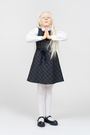 Schoolgirl posing with folded hands