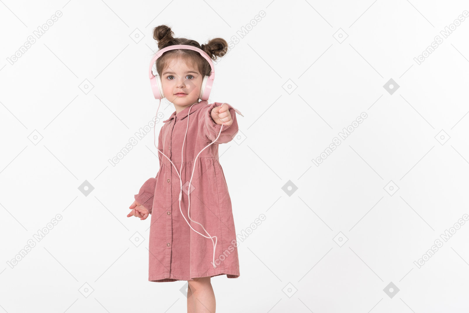 Little girl wearing headphones pointing forward
