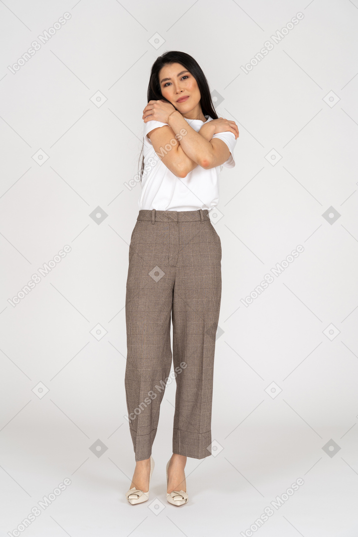 Vista frontal de uma jovem senhora de calça e camiseta se abraçando