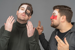 Front view of two male football fans sharing their emotions