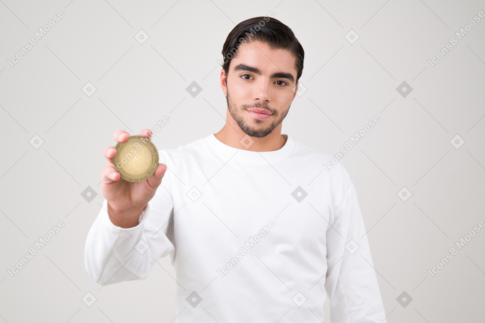 Handsome young man holding an iota coin