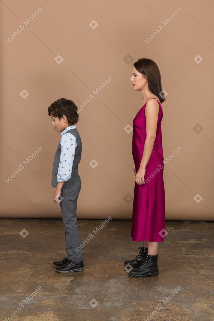 Mujer y niño de pie en el perfil