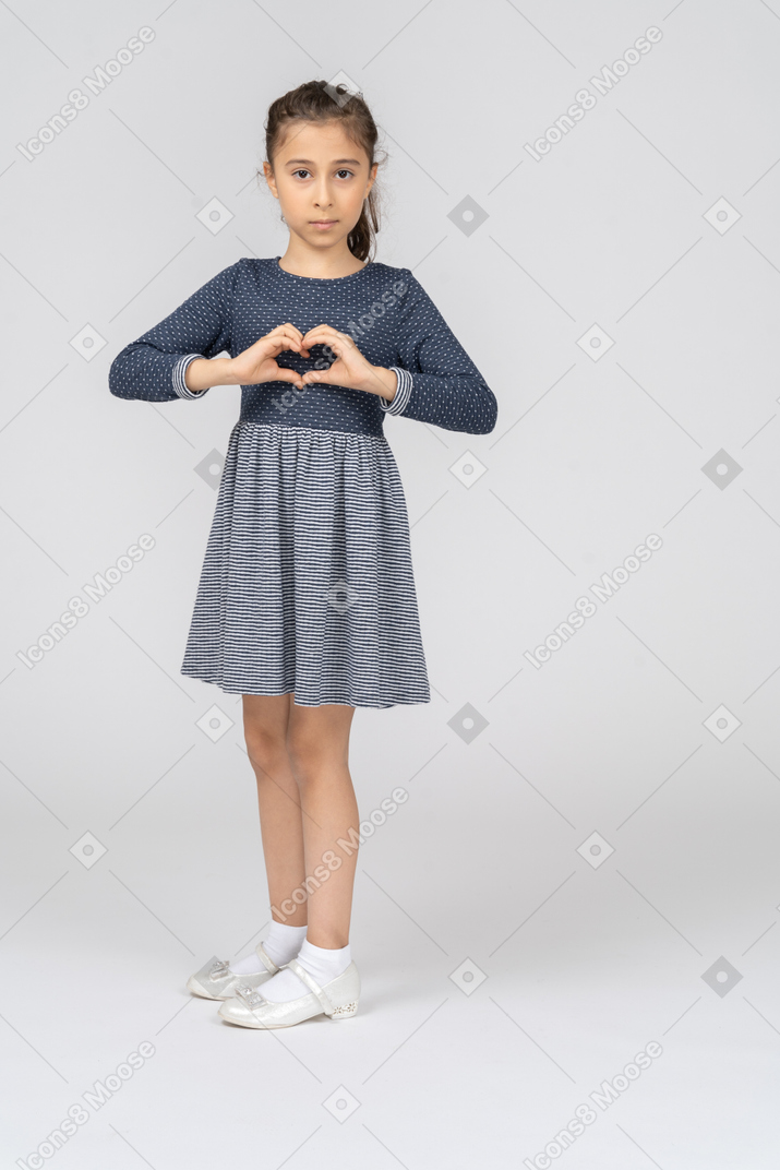 Three-quarter view of a girl turning and making heart with her hands