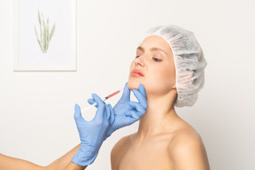 Woman looking uncomfortable during filler injection