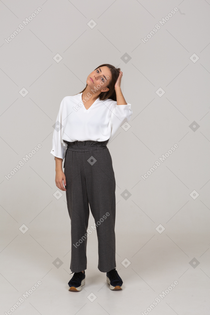 Front view of a young lady in office clothing touching her head