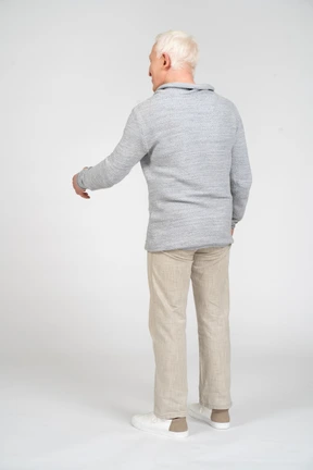 Vista trasera, de, un, hombre estar de pie, y, extensión, el suyo, brazo izquierdo