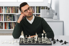 A man sitting at a table with a chess board