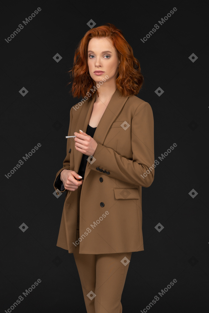Stylish young woman in a suit holding a cigarette