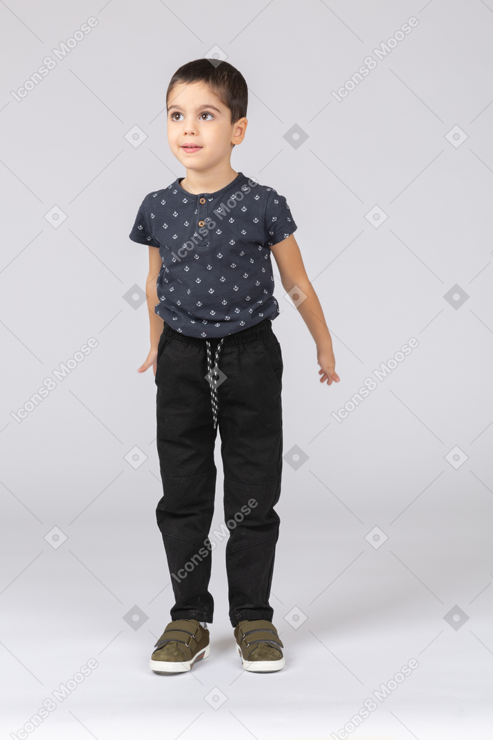 Front view of a cute boy in casual clothes ready to jump
