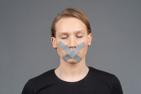 Person with duct tape on mouth and eyes closed