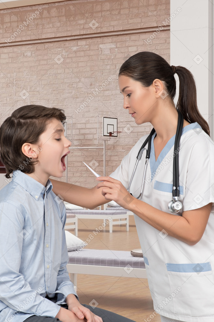 A young boy is being examined by a nurse