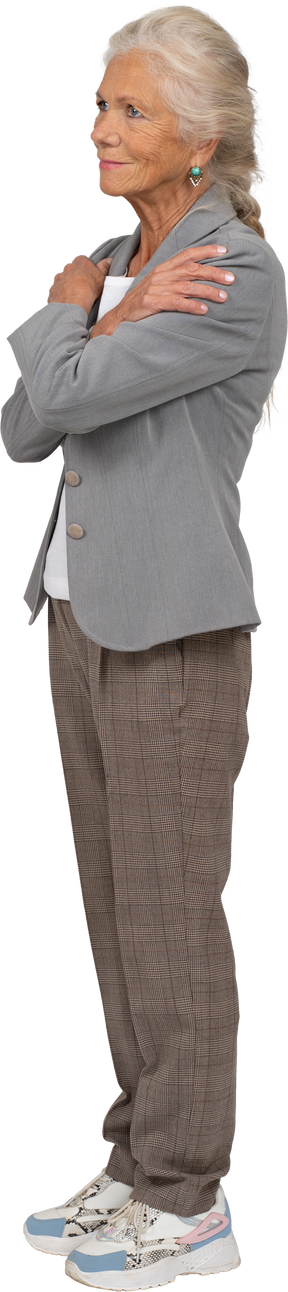 Side view of an old lady in suit hugging herself