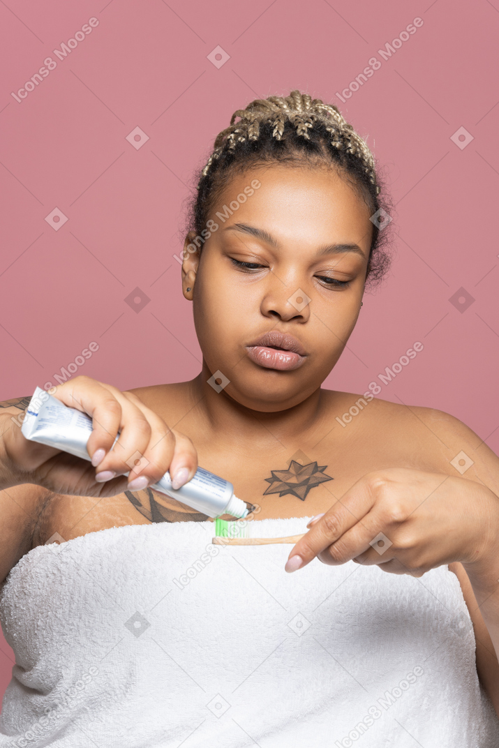 Woman squeezing toothpaste on a toothbrush