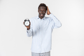Shocked young afroman holding alarm clock