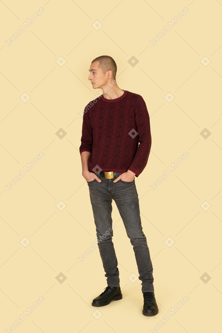 Front view of a young male in casual clothes putting hands in pockets