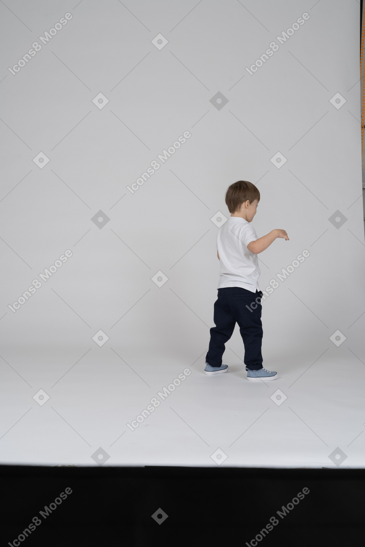 Vista traseira de um menino levantando os braços