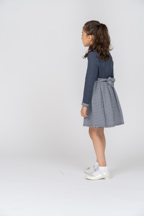 Three-quarter back view of a girl stepping forward