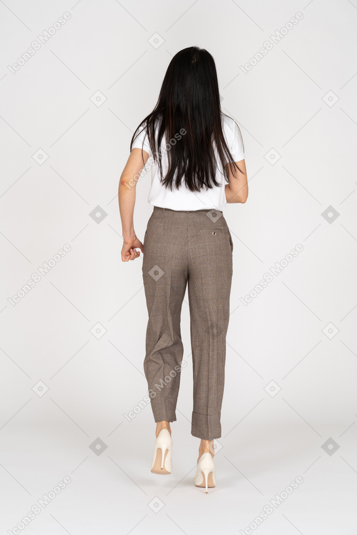 Back view of a running young lady in breeches and t-shirt
