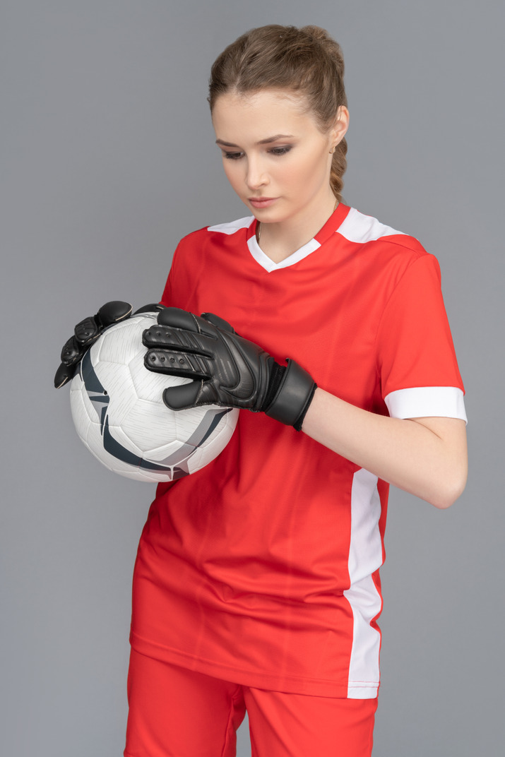 A female goalkeeper holding a ball