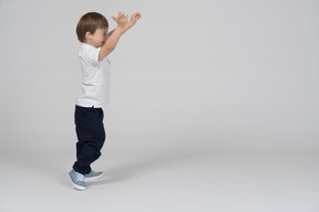 Vista lateral de un niño saltando emocionado