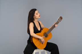 Jeune femme, apprécier, jouer guitare