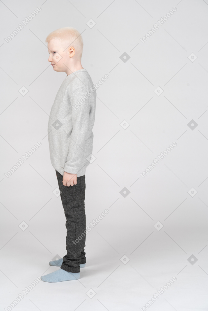 一个孩子男孩穿着休闲服放在一边看的侧视图