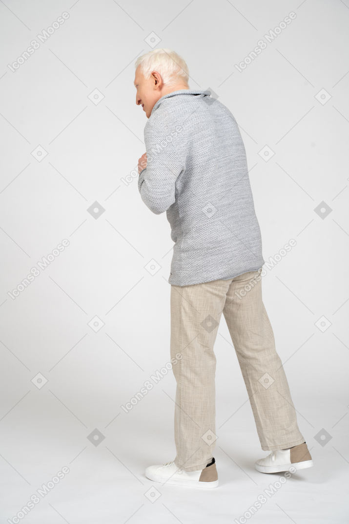 Vista lateral de un hombre caminando con los brazos cruzados