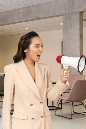 A woman holding a megaphone and yelling into it