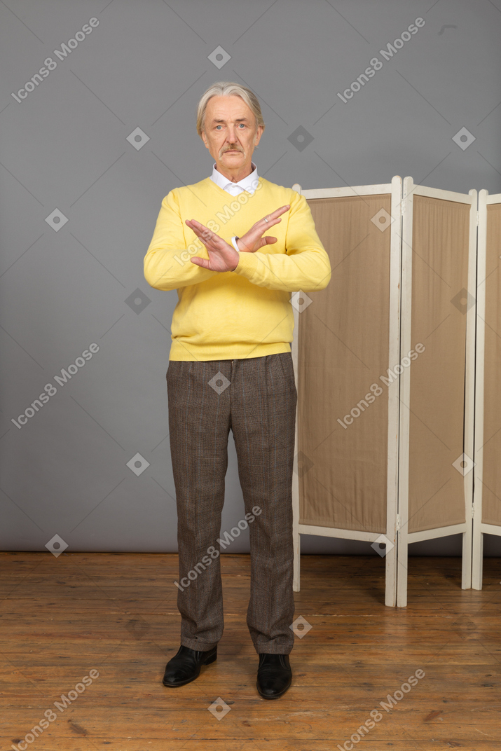 Front view of an unwilling old man crossing hands