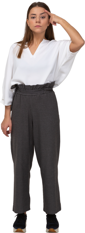 Front view of a young lady in office clothing looking at camera & touching head