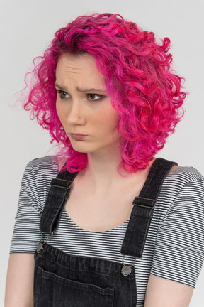 Portrait d'une jeune fille caucasienne froncée aux cheveux roses