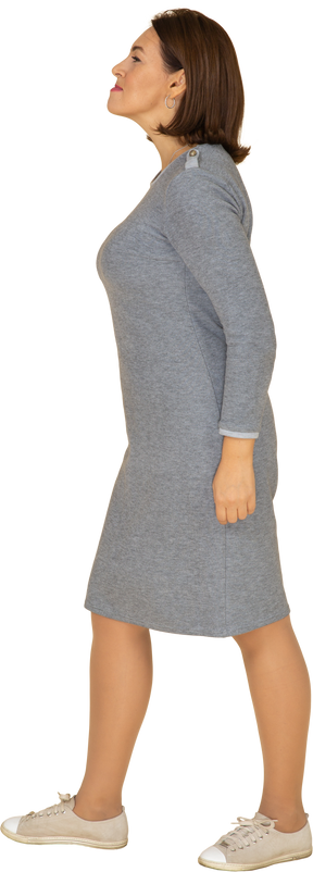 Vista laterale di una donna in abito grigio che fa smorfie