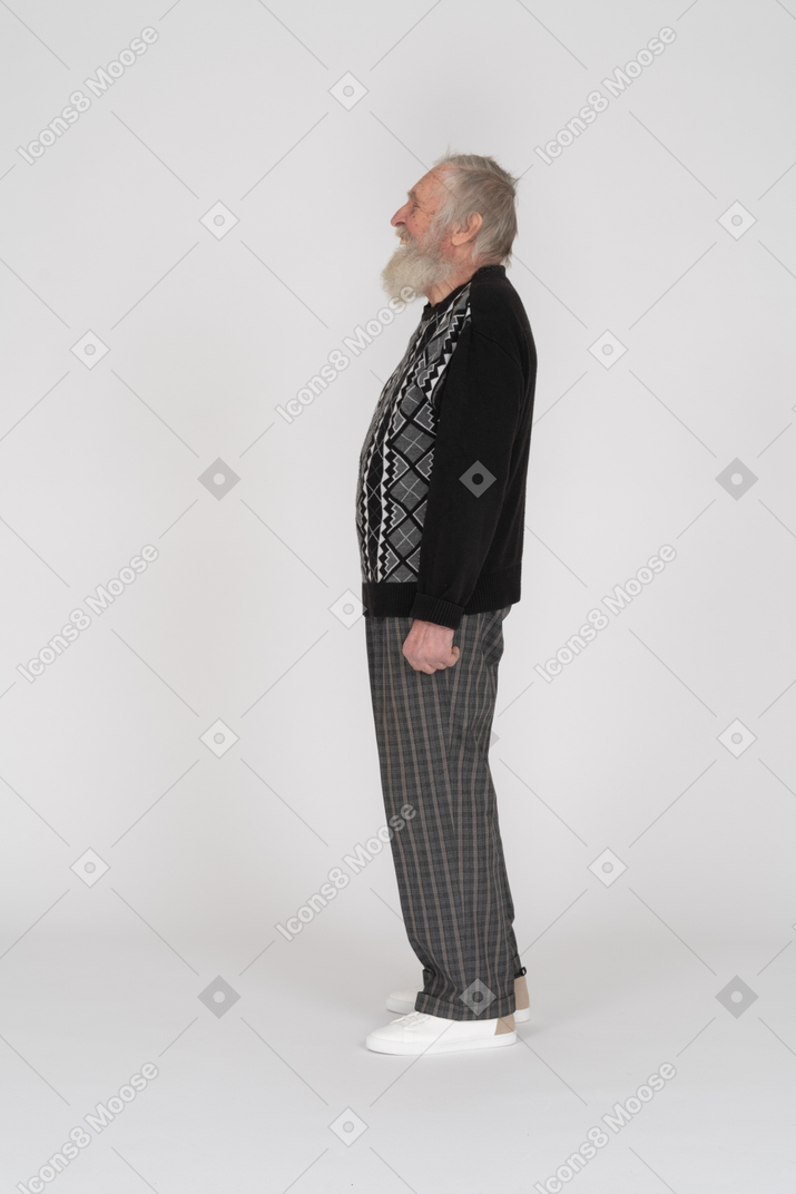 Vista lateral de un anciano de pie y riendo