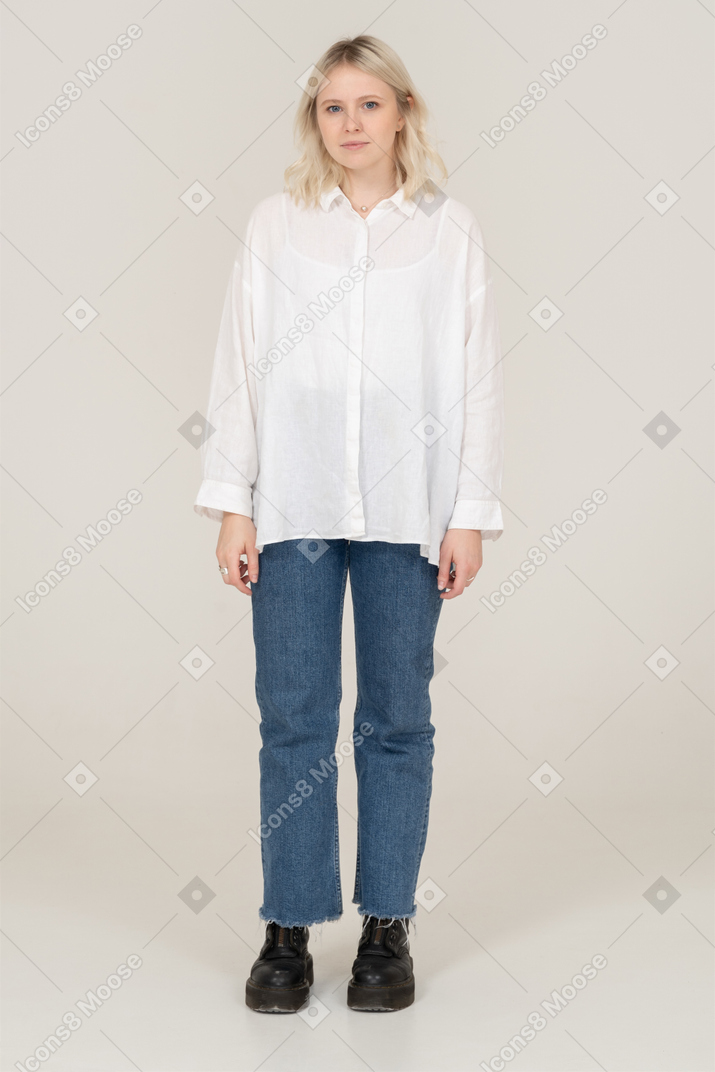 Front view of a cute blonde female in casual clothes looking at camera