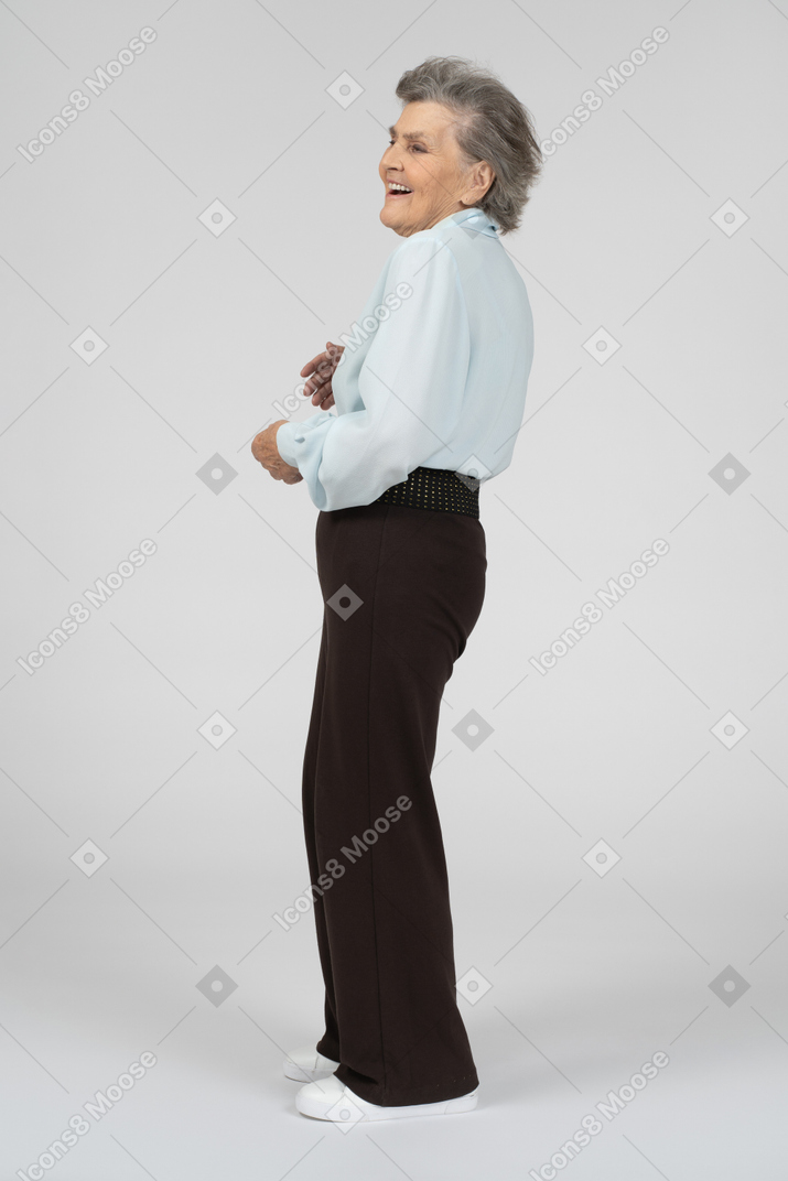 Vista lateral de una anciana riendo