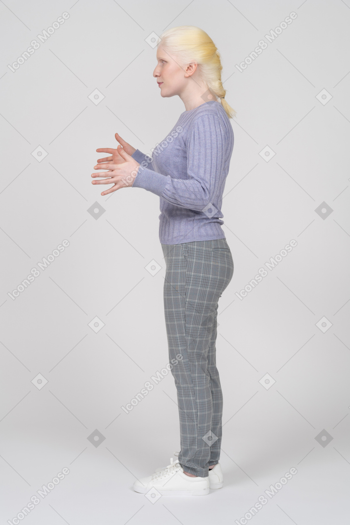 Side view of young woman explaining and gesturing with hands