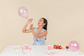 Jovem mulher asiática comemorando aniversário e brincando com balão