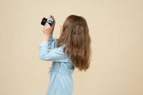 Bambina carina che tiene una macchina fotografica