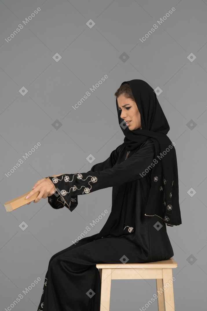 Young arab woman rejecting to read a book