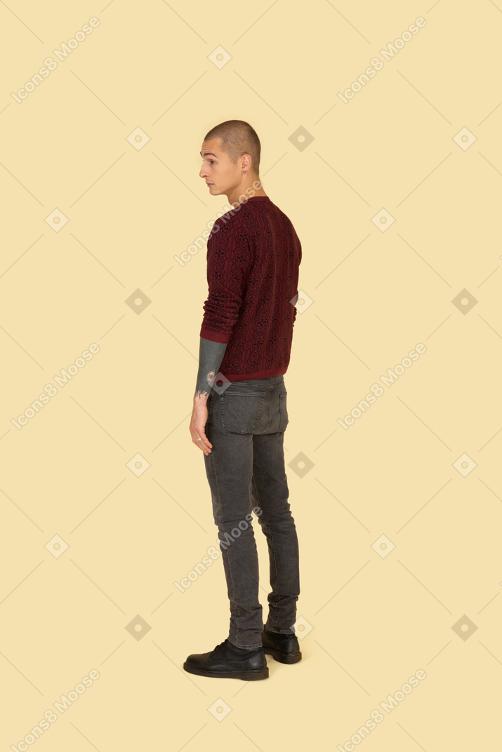一个年轻人穿着一件红色毛衣的四分之三后视图