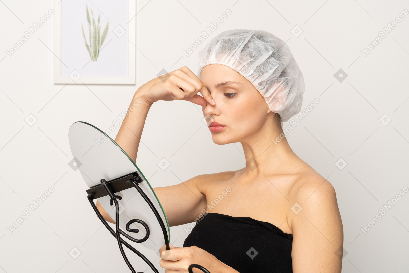 Mujer joven con espejo tocándose la nariz