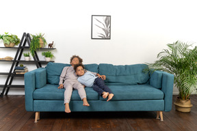 Good looking boy and girl play on the sofa