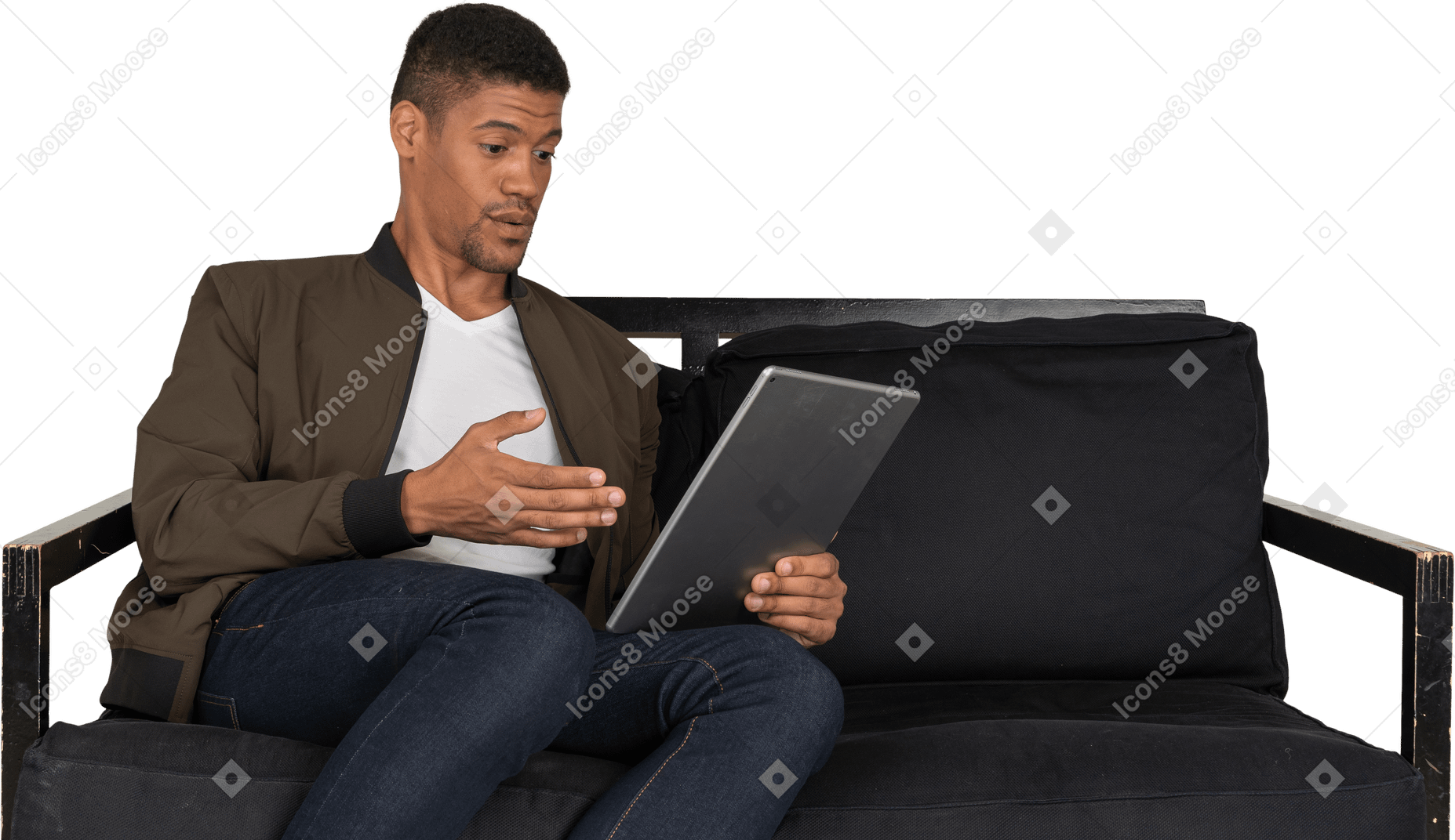 一个震惊的年轻人坐在沙发上看平板电脑的前视图
