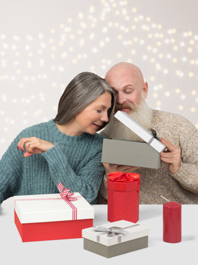 Пожилая пара обменивается рождественскими подарками