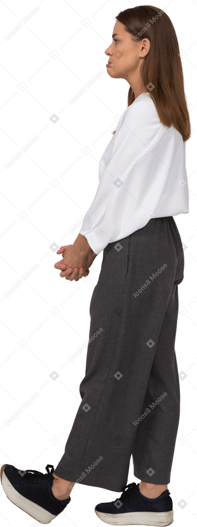 Vista lateral de uma jovem descontente com roupas de escritório, de mãos dadas