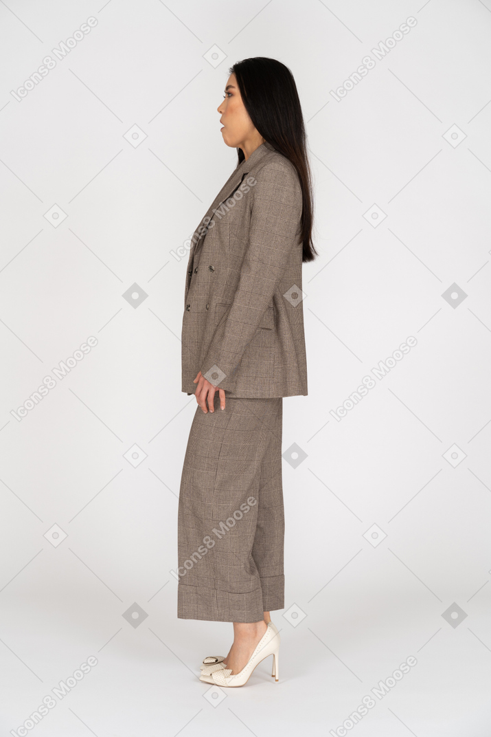 Vista lateral de uma jovem descontente em um terno marrom