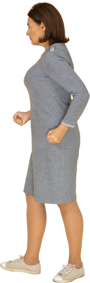 Vista laterale di una donna arrabbiata in abito grigio