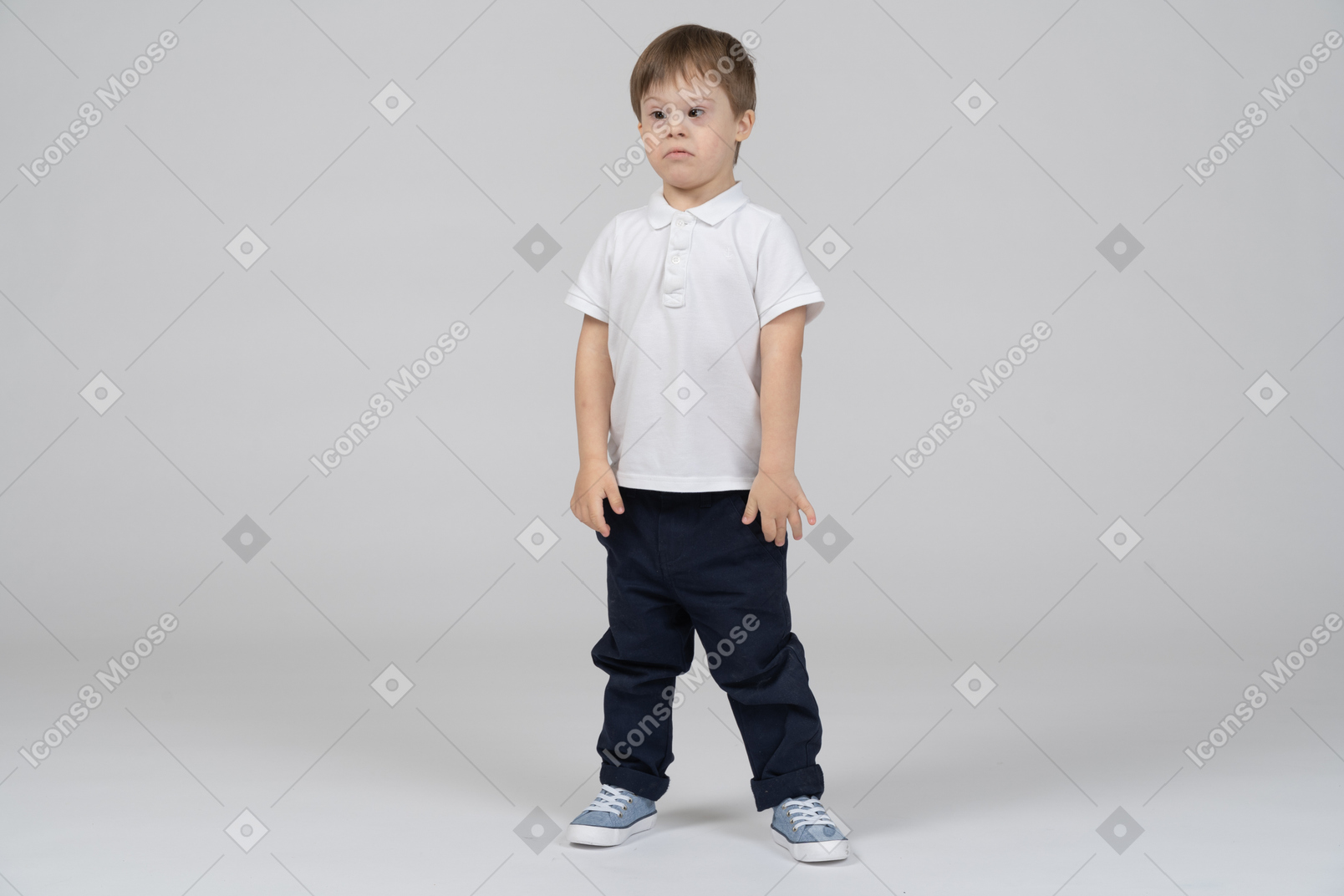 Sad little boy standing with arms at sides