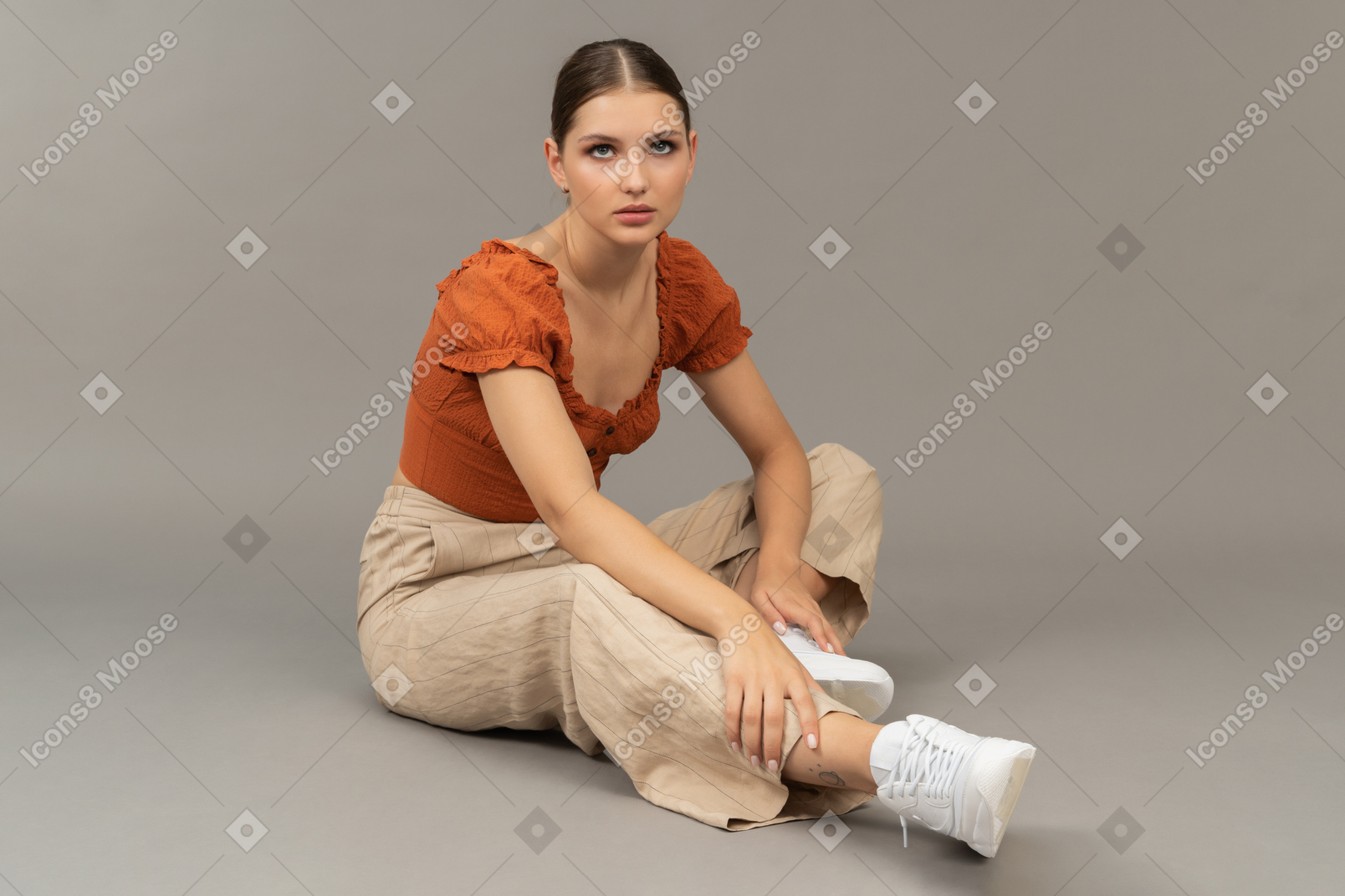 Красивая девушка сидит на полу, обняв колени Stock-Foto | Adobe Stock