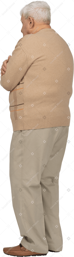 Vista lateral de un anciano con ropa informal abrazándose a sí mismo